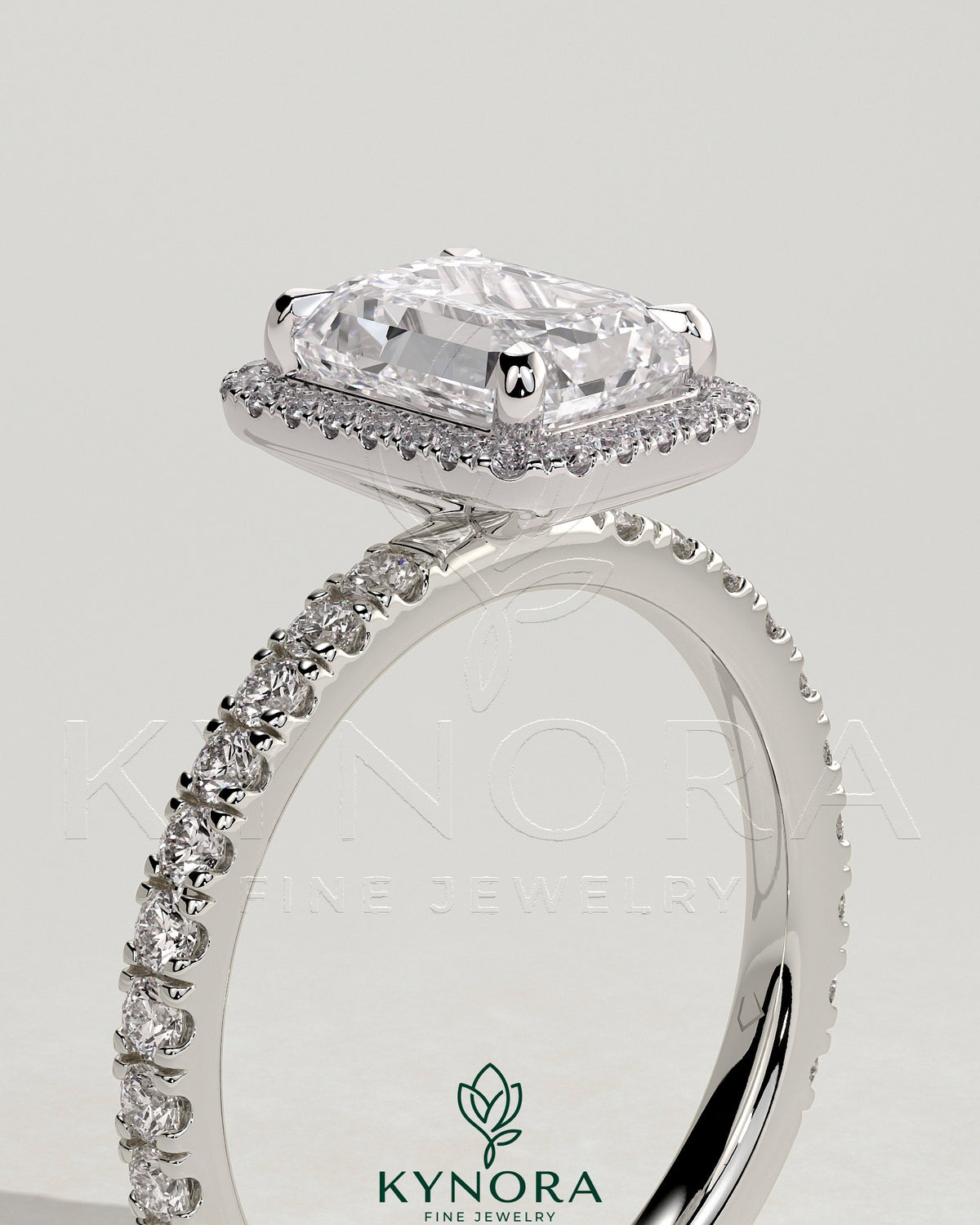 Kynora CJ 2ct emerald claw solitaire engagement ring with halo and pave band, showcasing sparkling emerald center stone and intricate setting.