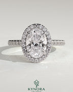 Kynora CJ 2ct oval claw solitaire engagement ring with halo, pave band, and cathedral high setting showcasing detailed craftsmanship.