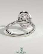 Kynora CJ 2ct oval claw solitaire engagement ring with halo, pave band, and cathedral high setting, showcasing intricate jewelry details.