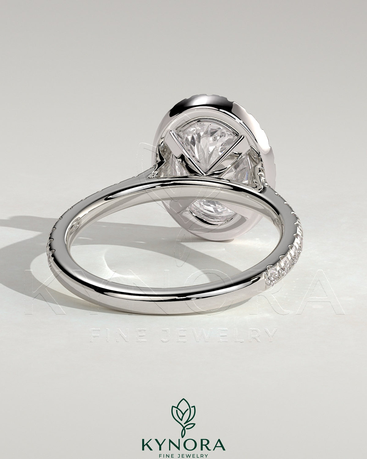 Kynora CJ 2ct oval claw solitaire engagement ring with halo, pave band, and cathedral high setting, showcasing intricate jewelry details.