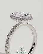 Kynora CJ 2ct oval claw solitaire engagement ring with halo and pave band, featuring sparkling diamond accents and a sleek design.