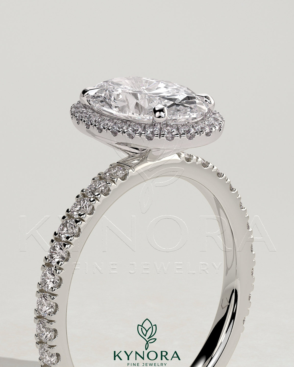 Kynora CJ 2ct oval claw solitaire engagement ring with halo and pave band, featuring sparkling diamond accents and a sleek design.