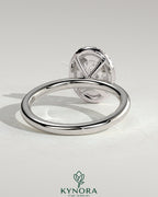 Kynora CJ 2ct oval claw solitaire engagement ring with a halo setting, featuring a central oval diamond and surrounding smaller stones.