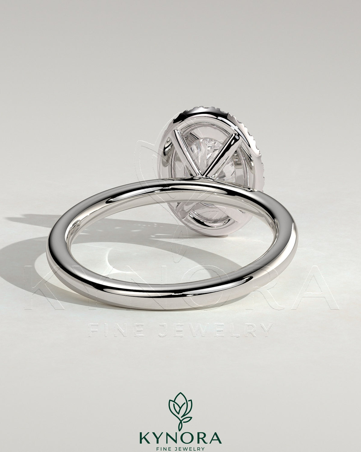 Kynora CJ 2ct oval claw solitaire engagement ring with a halo setting, featuring a central oval diamond and surrounding smaller stones.