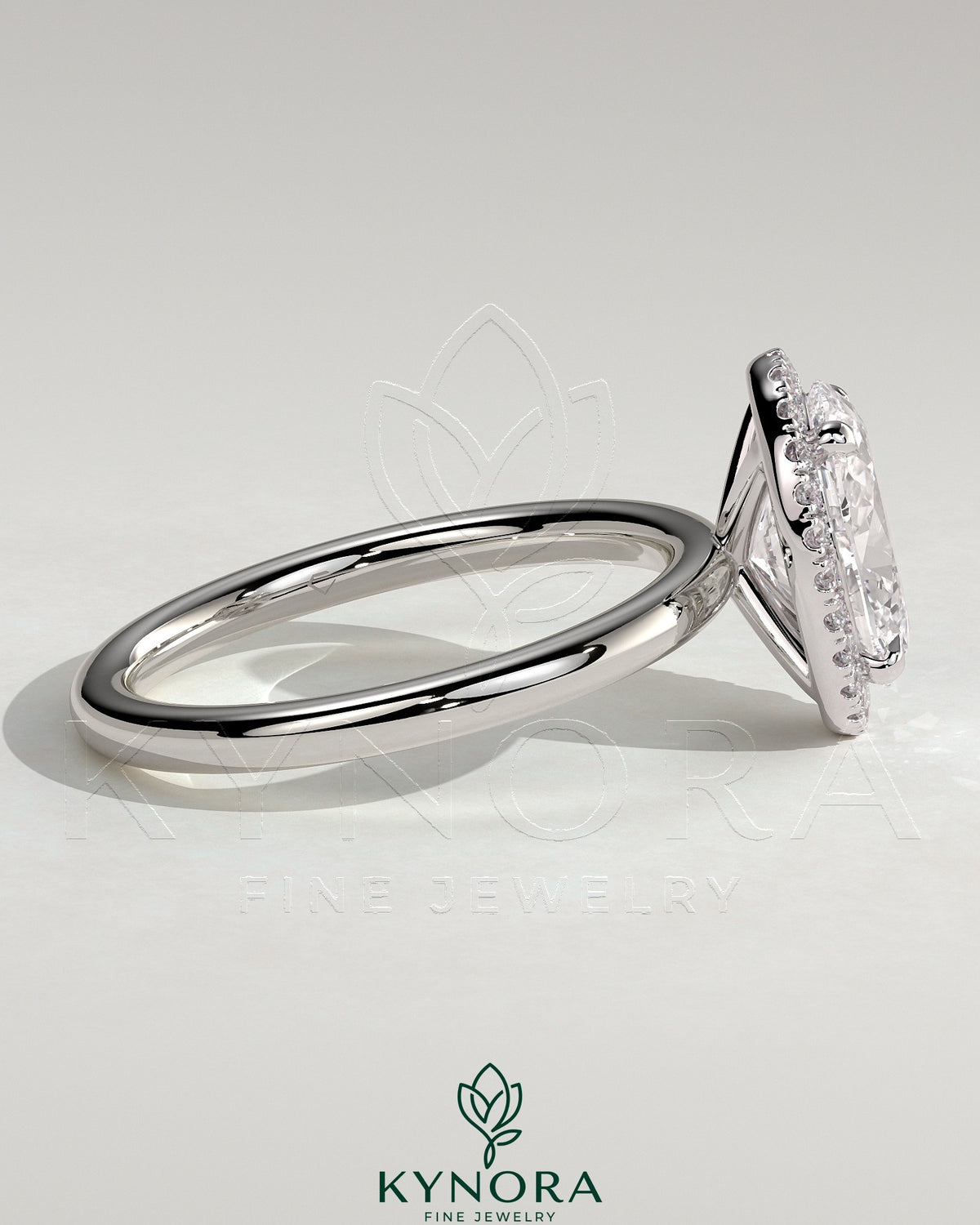 Kynora CJ 2ct oval claw solitaire engagement ring with halo of small diamonds, featuring a sleek gold band.