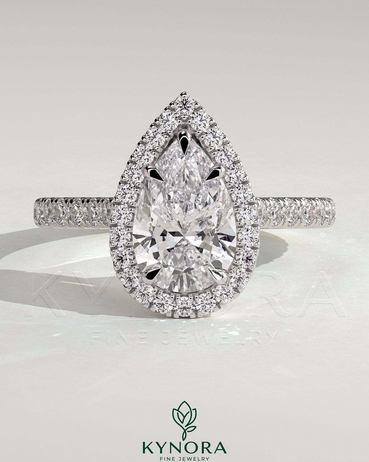 Kynora CJ 2ct pear-shaped diamond solitaire engagement ring with halo, pave band, and cathedral high setting. Imagen principal del producto