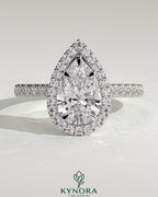 Kynora CJ 2ct pear-shaped diamond solitaire engagement ring with halo, pave band, and cathedral high setting.