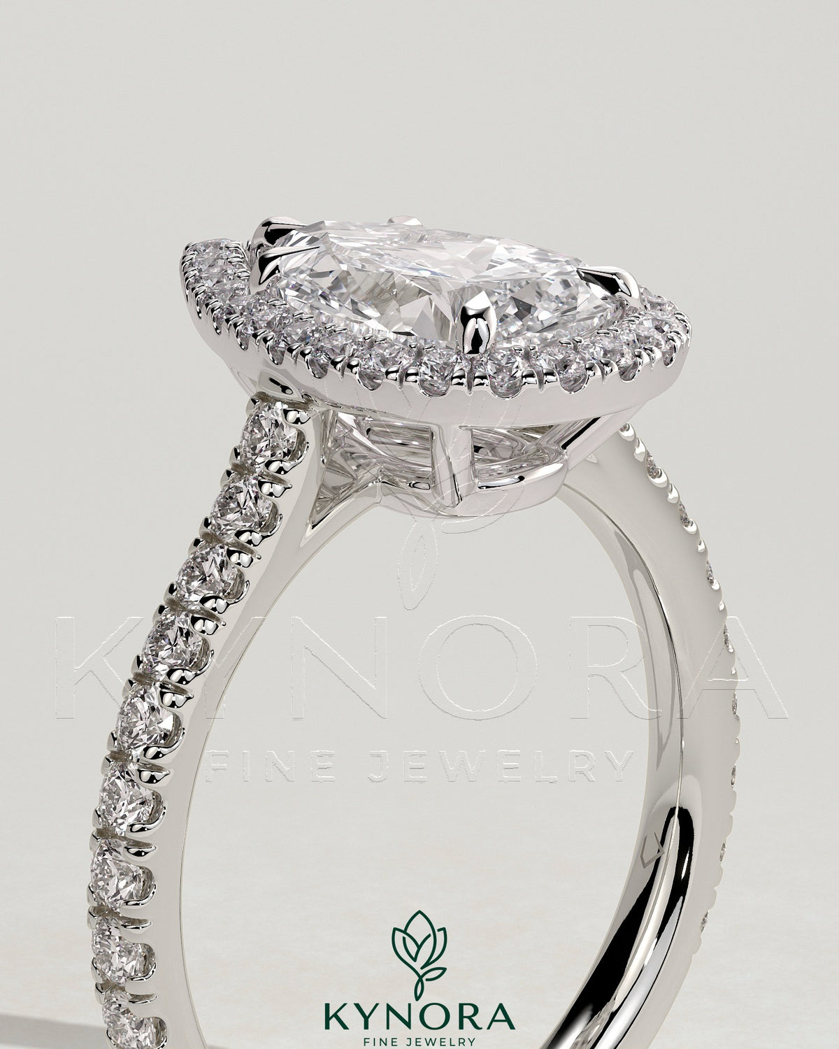 Kynora CJ 2ct pear-shaped diamond solitaire engagement ring with halo, pave band, and cathedral high setting displayed close-up.