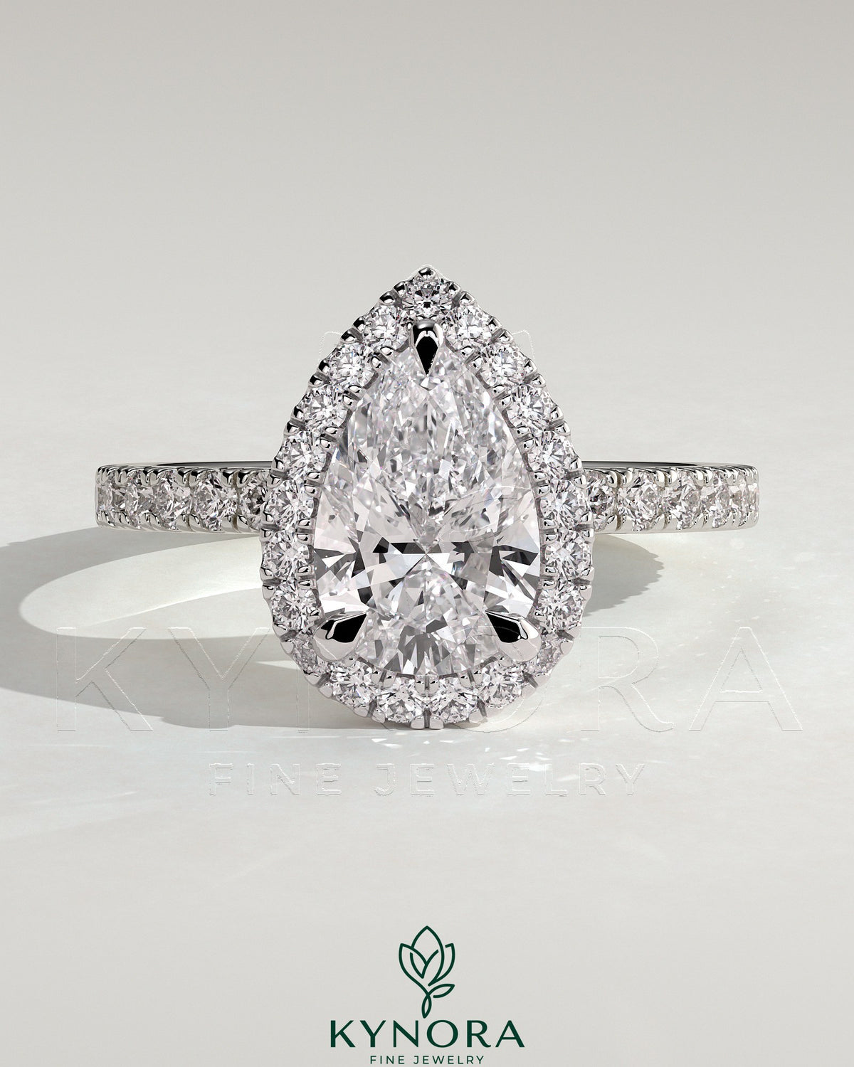 Kynora CJ 2ct pear-shaped diamond solitaire engagement ring with halo and pave band in elegant jewelry design. Imagen principal del producto