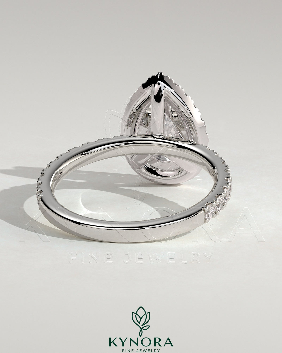 Kynora CJ 2ct pear-shaped diamond halo engagement ring with pave band showcasing sparkling jewelry design.