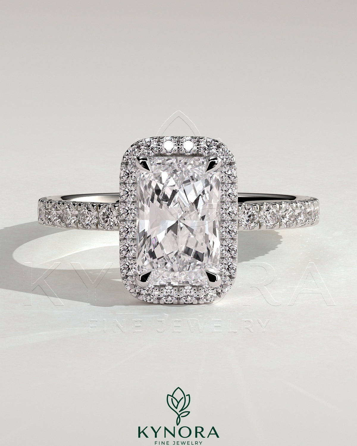 Kynora CJ 2ct radiant claw solitaire engagement ring with halo and pave band, showcasing sparkling diamond details. Imagen principal del producto