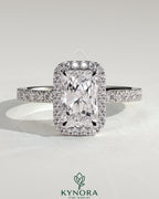Kynora CJ 2ct radiant claw solitaire engagement ring with halo and pave band, showcasing sparkling diamond details.
