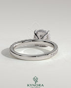 Kynora CJ 2ct cushion claw solitaire engagement ring with hidden halo and pave band, featuring sparkling diamond details.