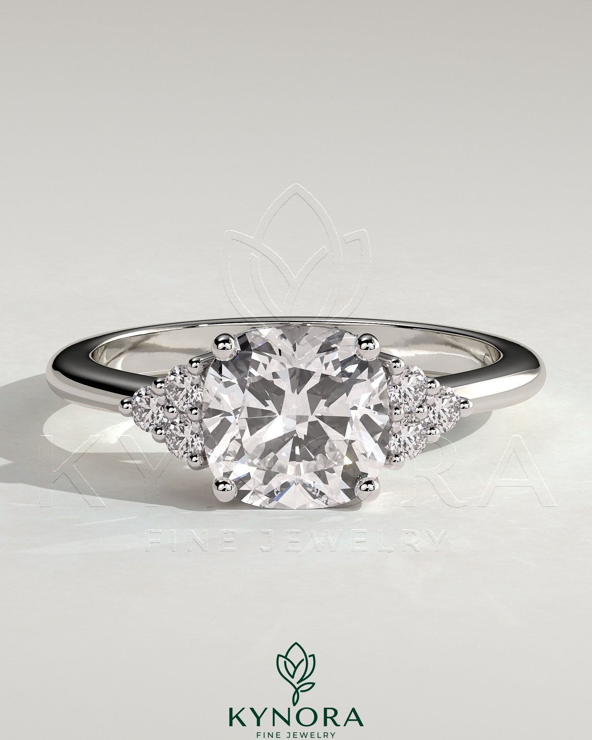 Kynora CJ 2-carat cushion claw solitaire engagement ring with round shoulder stones, featuring a sparkling central diamond and elegant design. Main image