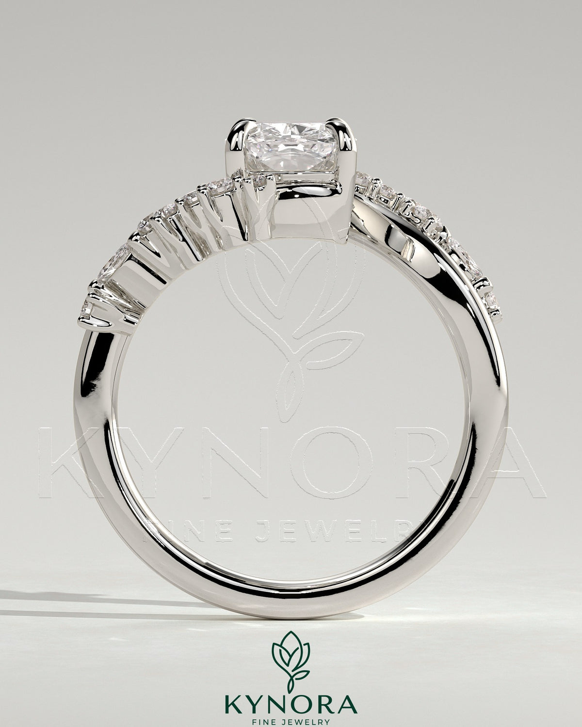 Kynora CJ 2ct elongated cushion claw solitaire engagement ring with bypass band and clustered round-marquise accent stones.