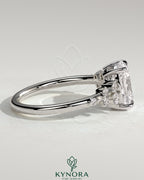 Kynora CJ 2ct elongated cushion claw solitaire engagement ring with clustered round shoulder stones and intricate band design.