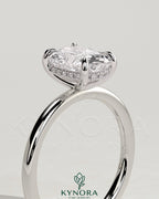 Kynora CJ 2ct elongated cushion diamond solitaire engagement ring with hidden halo, featuring a sleek gold band on a white background.