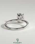 Kynora CJ 2ct elongated cushion solitaire engagement ring with petal gallery and leaf accents, featuring a sparkling central diamond.