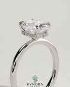 Kynora CJ 2ct elongated cushion cut solitaire engagement ring with wrap-around hidden halo in gold setting.