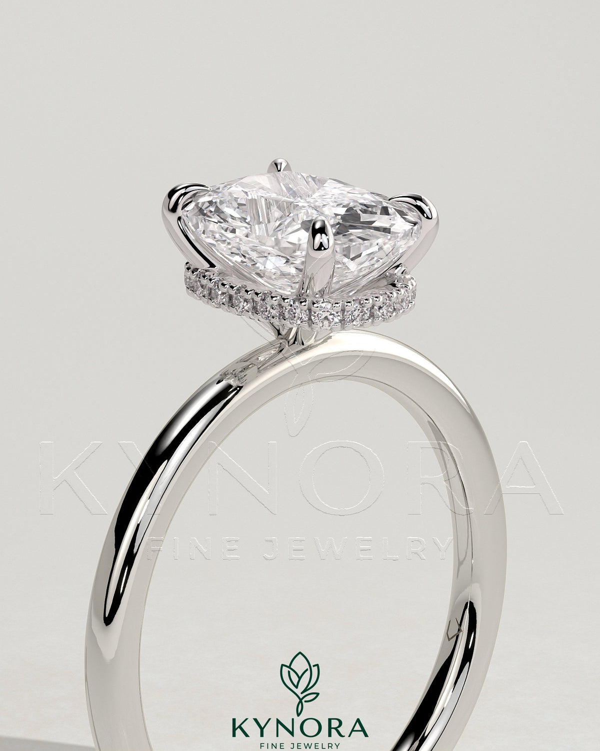 Kynora CJ 2ct elongated cushion cut solitaire engagement ring with wrap-around hidden halo in gold setting.