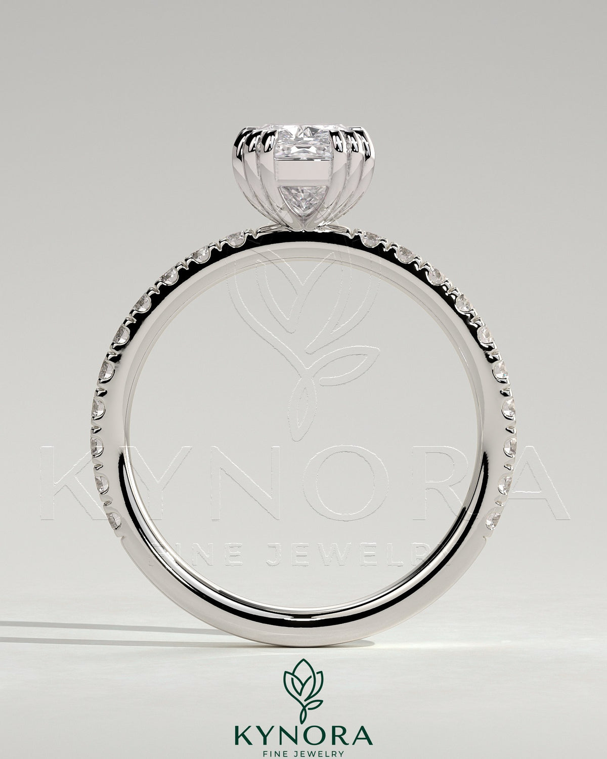 Kynora CJ 2ct elongated cushion triple claw solitaire engagement ring with pave band, featuring a sparkling central diamond and intricate setting.