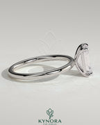 Kynora CJ 2ct emerald claw solitaire engagement ring with a central emerald-cut diamond and a sleek silver band.