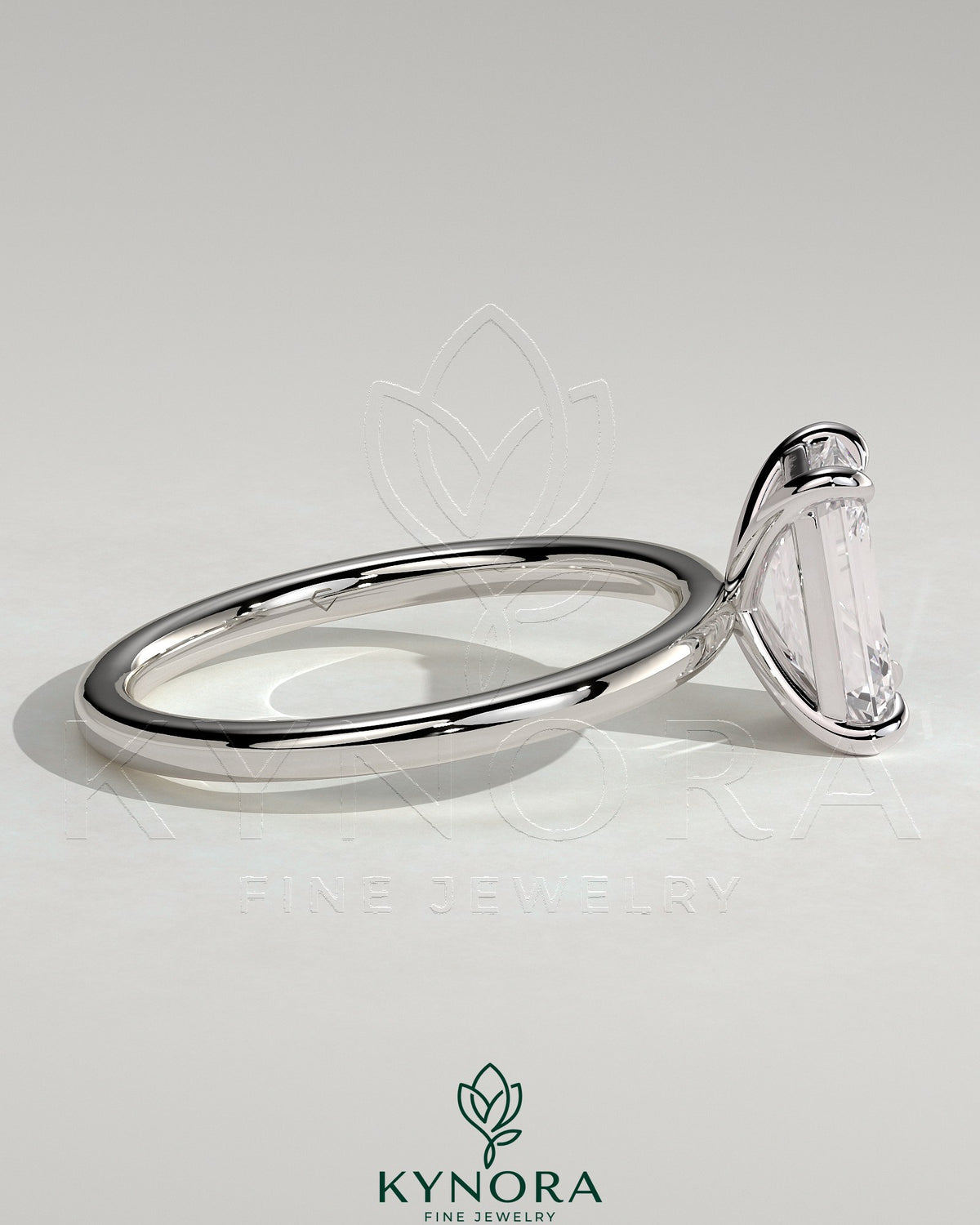 Kynora CJ 2ct emerald claw solitaire engagement ring with a central emerald-cut diamond and a sleek silver band.