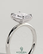 Emerald 2-carat claw solitaire engagement ring by Kynora CJ featuring a central emerald gemstone set in a sleek band.