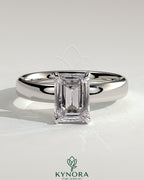 Kynora CJ 2ct emerald claw solitaire engagement ring with cigar band and hidden halo, showcasing a sparkling emerald centerpiece.