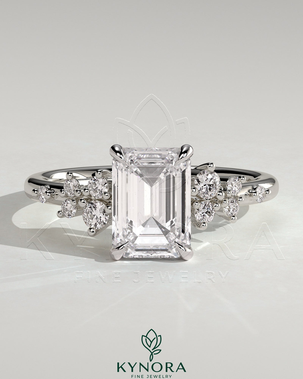 Kynora CJ 2ct emerald claw solitaire engagement ring with round cluster shoulder stones, showcasing elegant design and sparkling gemstones. Main image