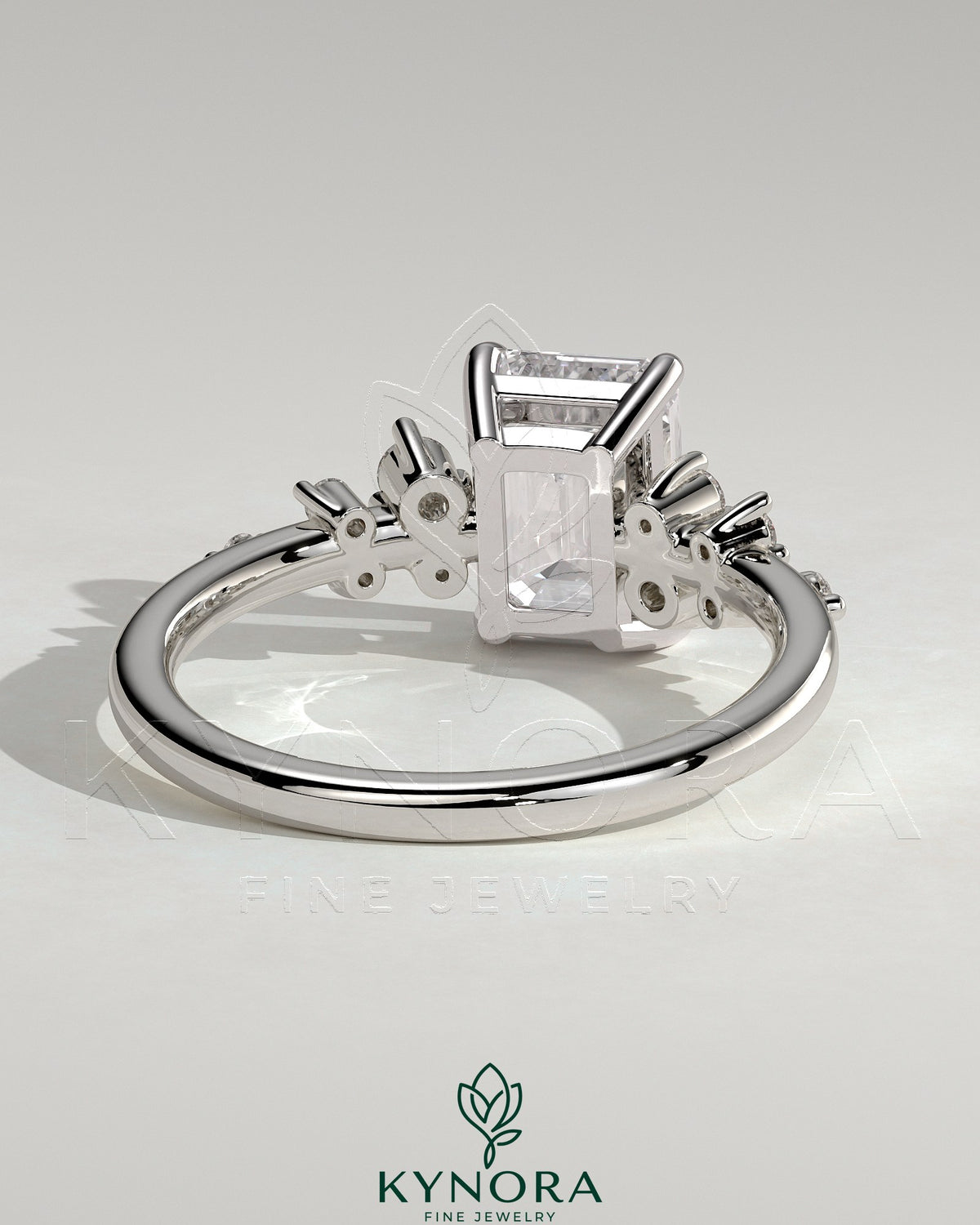 Kynora CJ 2ct emerald claw solitaire engagement ring with clustered round shoulder stones, showcasing elegant jewelry craftsmanship.
