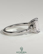 Kynora CJ 2ct emerald claw solitaire engagement ring with clustered round shoulder stones, showcasing elegant jewelry design.