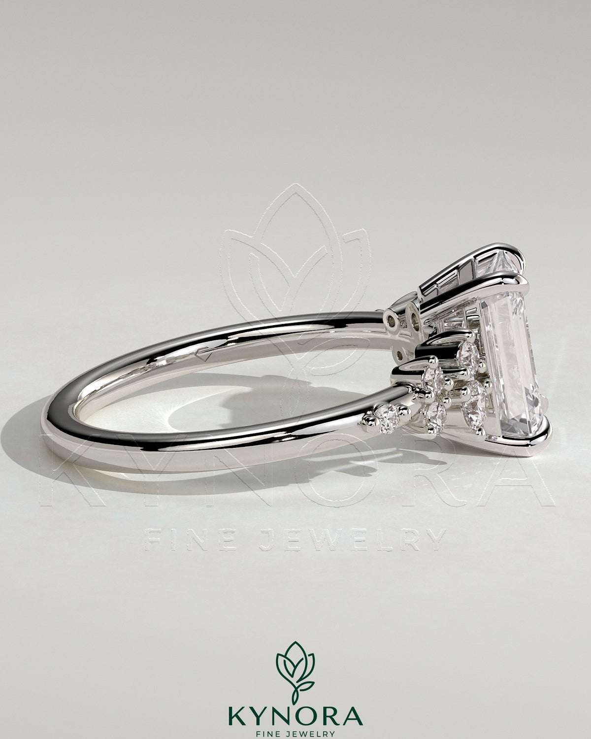 Kynora CJ 2ct emerald claw solitaire engagement ring with clustered round shoulder stones, showcasing elegant jewelry design.
