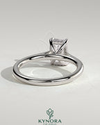Kynora CJ 2ct emerald claw solitaire engagement ring with hidden halo and cathedral high setting, showcasing a sparkling green gemstone.
