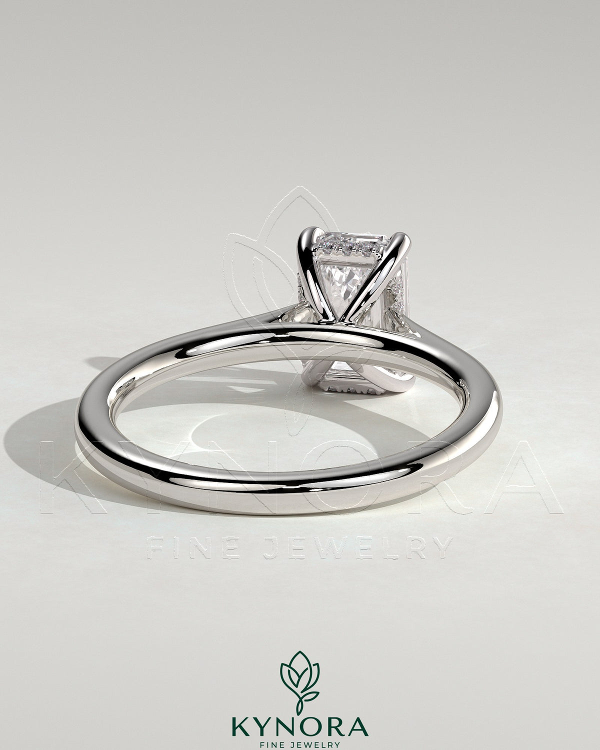 Kynora CJ 2ct emerald claw solitaire engagement ring with hidden halo and cathedral high setting, showcasing a sparkling green gemstone.