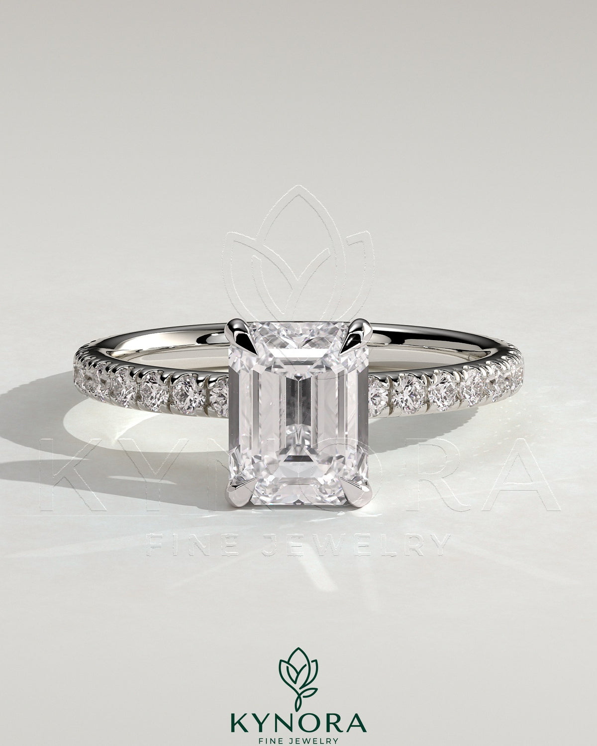 Kynora CJ 2ct emerald claw solitaire engagement ring with hidden halo and pave band, showcasing a sparkling emerald center stone. Main image
