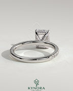 Kynora CJ 2ct emerald claw solitaire engagement ring with hidden halo and pavé band, showcasing intricate diamond setting and craftsmanship.