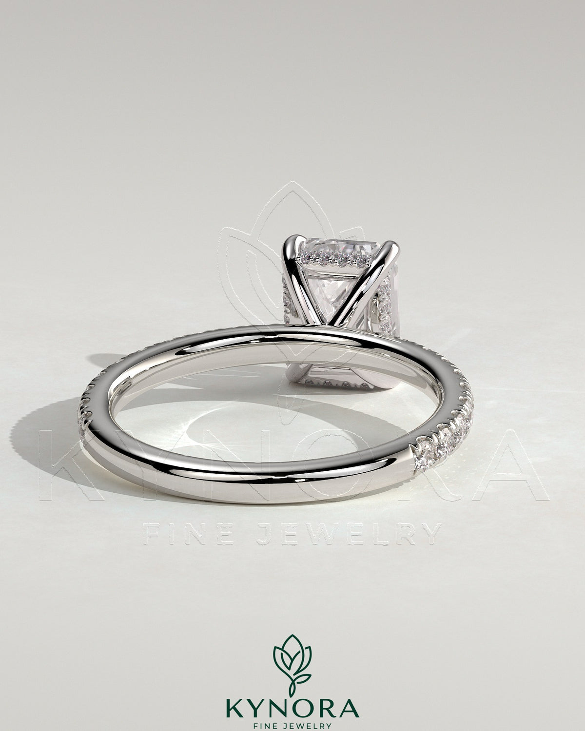 Kynora CJ 2ct emerald claw solitaire engagement ring with hidden halo and pavé band, showcasing intricate diamond setting and craftsmanship.