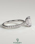 Kynora CJ 2ct emerald claw solitaire engagement ring with hidden halo and pave band, showcasing elegant diamond setting and design.