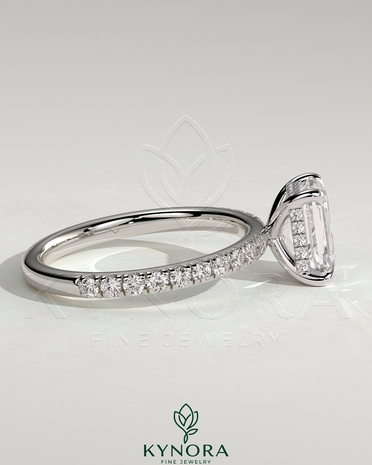 Kynora CJ 2ct emerald claw solitaire engagement ring with hidden halo and pave band, showcasing elegant diamond setting and design.