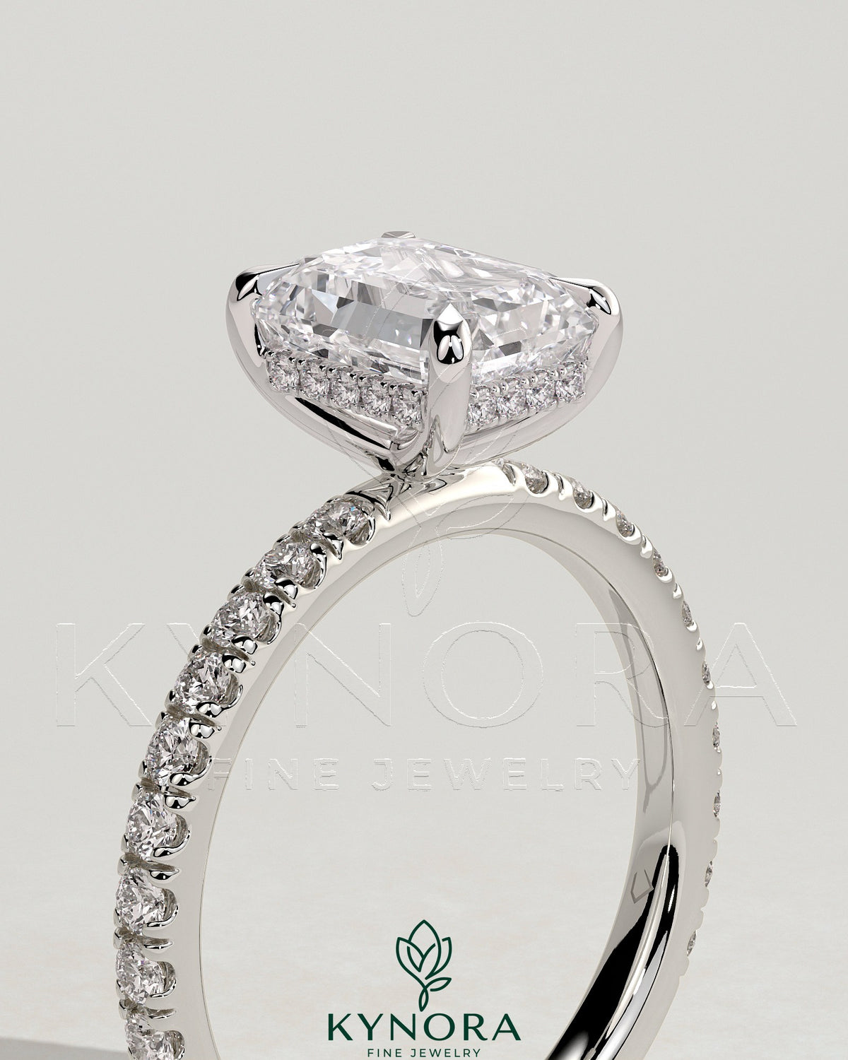 Kynora CJ 2ct emerald claw solitaire engagement ring with hidden halo and pave band, showcasing intricate design and sparkling gemstone.