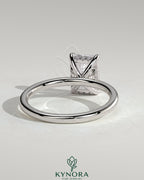 Kynora CJ 2ct emerald claw solitaire engagement ring with hidden halo, featuring a central emerald-cut gemstone and intricate design.
