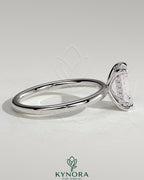 Kynora CJ 2ct emerald claw solitaire engagement ring with hidden halo, featuring a central emerald-cut gemstone and intricate band design.