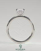 Kynora CJ 2ct emerald claw solitaire engagement ring with hidden halo, featuring a central emerald-cut gemstone and intricate band details.