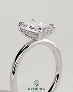 Kynora CJ 2ct emerald claw solitaire engagement ring with hidden halo, featuring a stunning central emerald gemstone and elegant design.