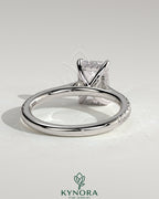 Kynora CJ 2ct emerald claw solitaire engagement ring with hidden halo, pave band, and cathedral high setting, showcasing fine craftsmanship.