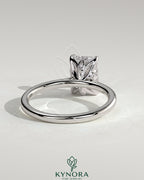 Kynora CJ 2ct emerald claw solitaire engagement ring with petal gallery, leaf accents, and cathedral setting in silver jewelry style.