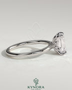 Kynora CJ 2ct emerald claw solitaire engagement ring with petal gallery, leaf accents, and cathedral setting.