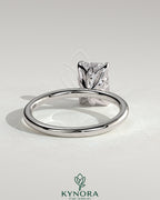 Kynora CJ 2ct emerald claw solitaire engagement ring with petal gallery and leaf accents, crafted in elegant jewelry style.