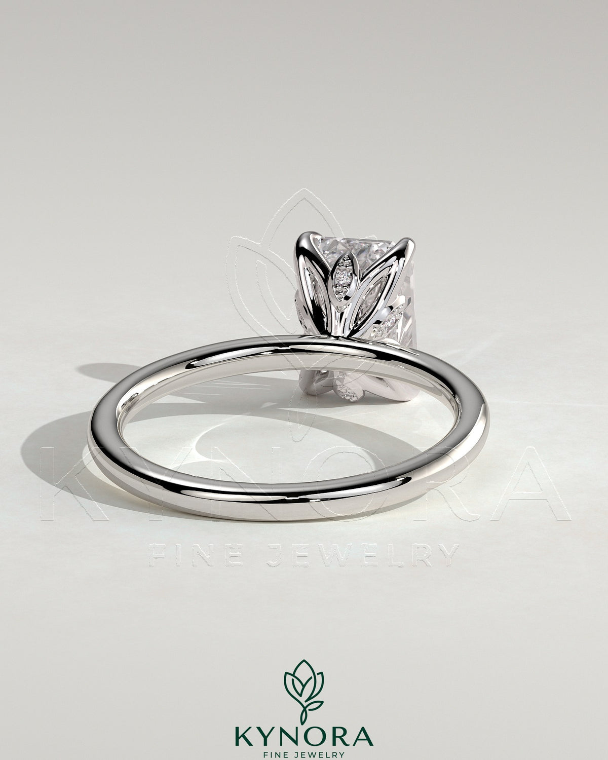 Kynora CJ 2ct emerald claw solitaire engagement ring with petal gallery and leaf accents, crafted in elegant jewelry style.